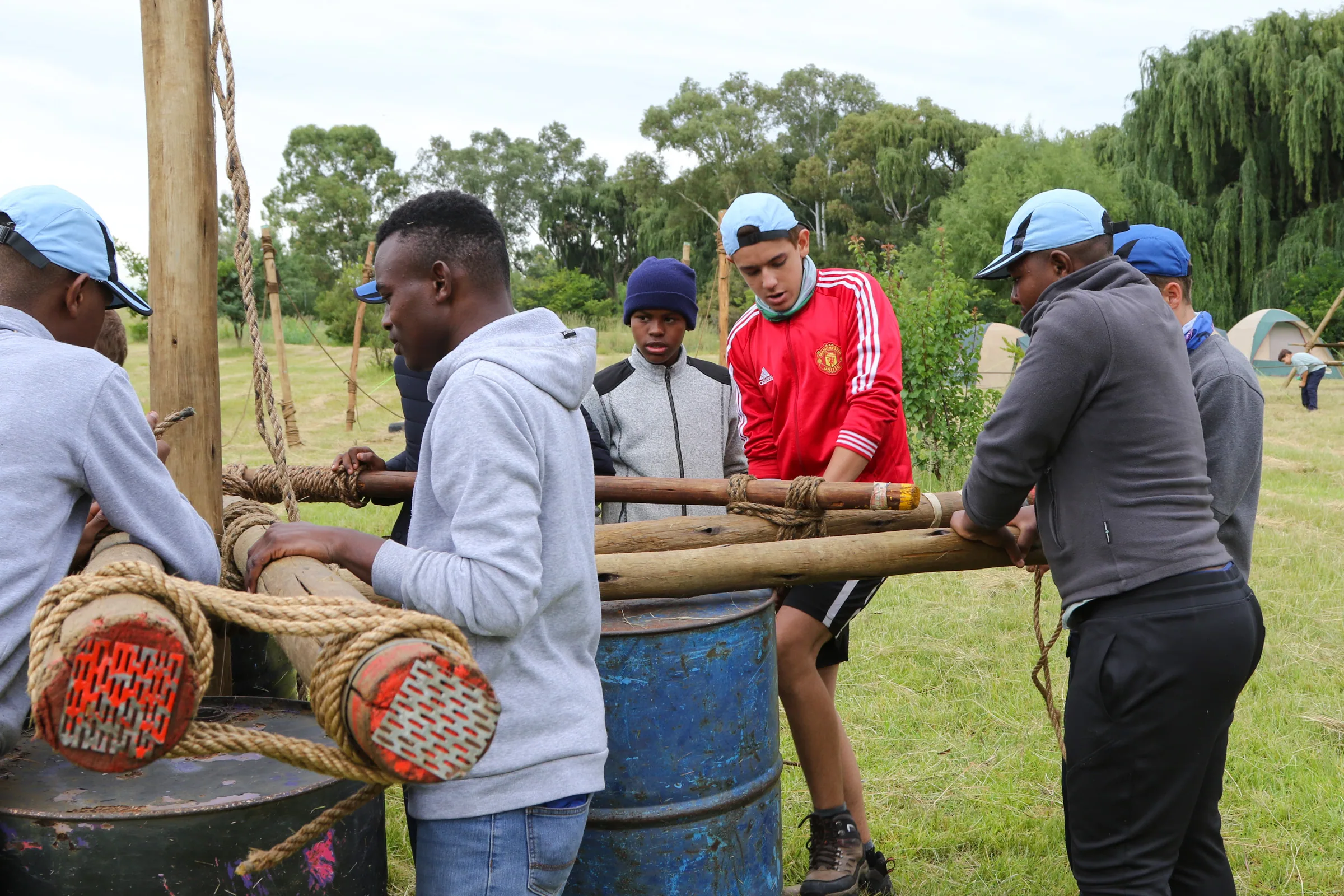 Scouts working together to lash poles for a pioneering project